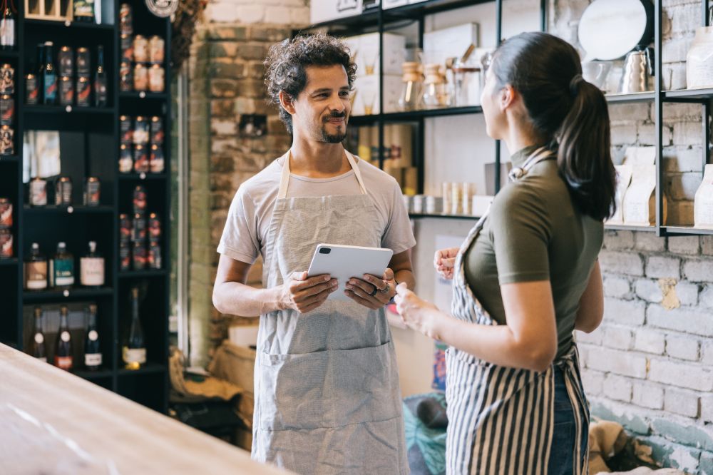 Two franchise team members discussing operations in a store, representing how to prevent assumptions in multi-unit franchise succession through clear communication and aligned expectations.