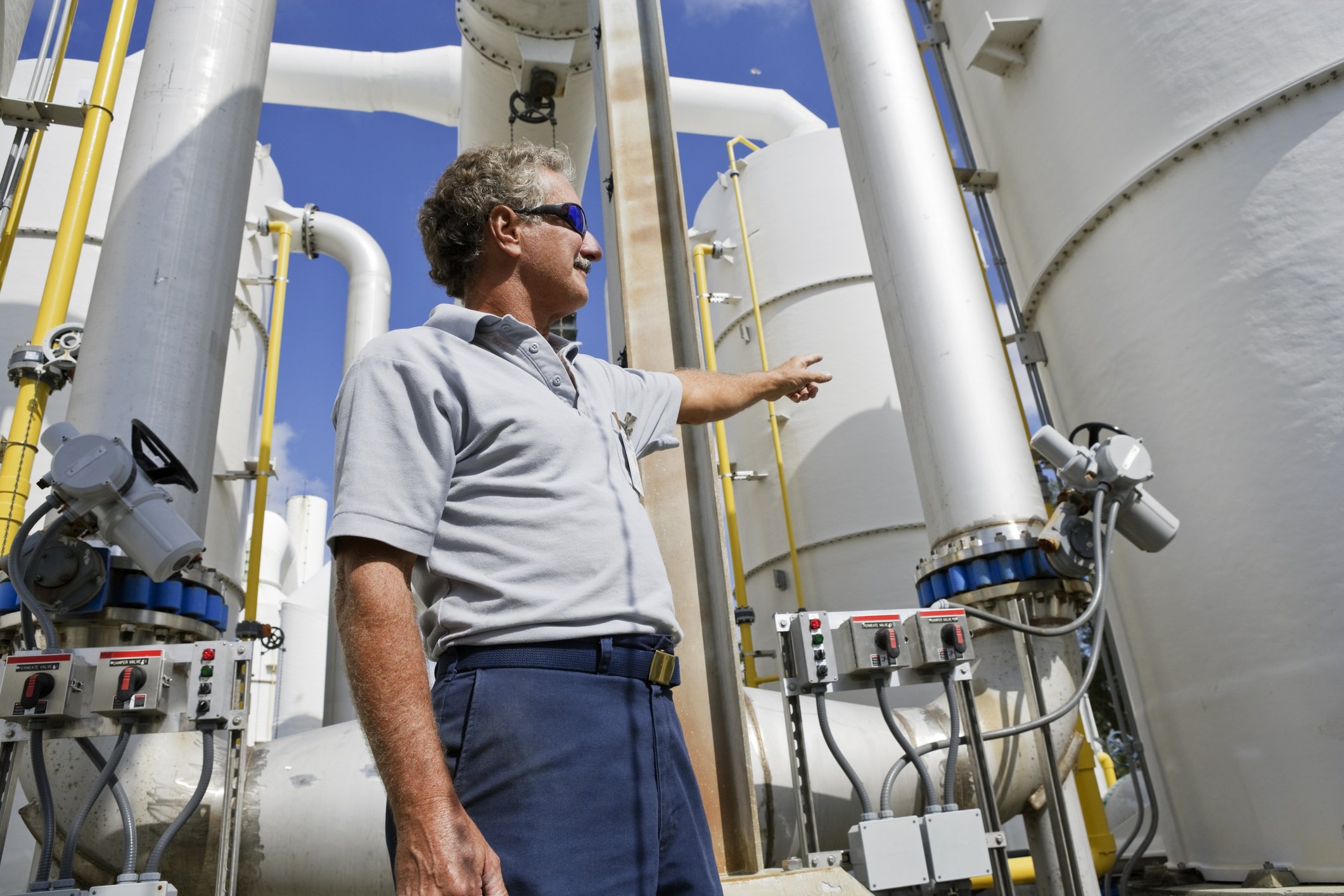 Propane business owner standing near fuel storage tanks while evaluating estate planning and business transition risk.