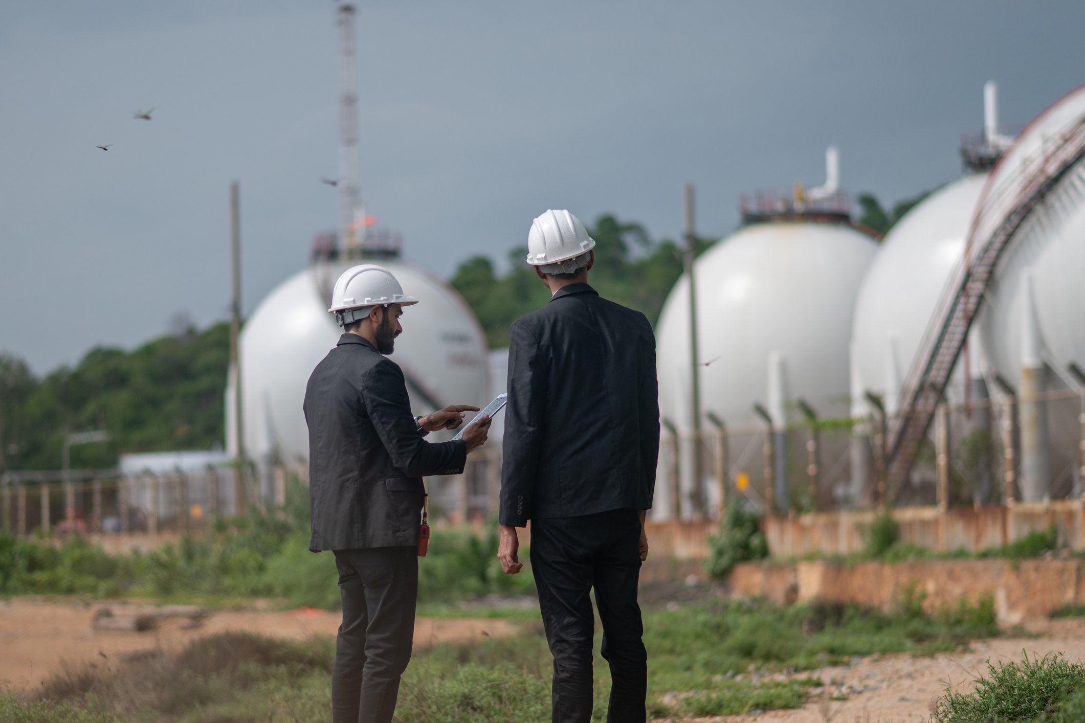 Two business leaders reviewing a propane storage facility as part of leadership succession planning for a propane company